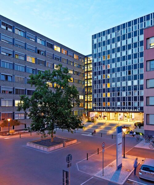 Beleuchteter Eingangsbereich eines modernen Klinikgebäudes am Abend.