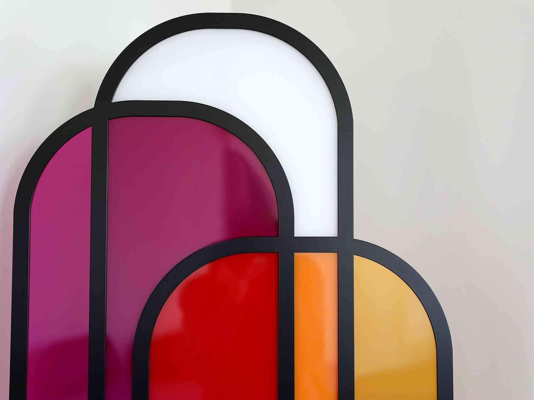 Abstraktes Wandkunstwerk aus farbigen, gebogenen Flächen in Rot, Orange, Pink und Weiß, eingefasst in schwarze Konturen.