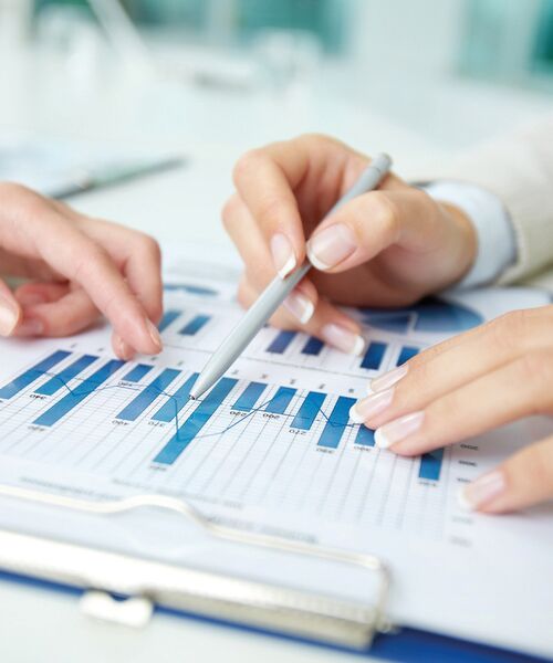 Zwei Personen analysieren gemeinsam ein Diagramm mit blauen Balken – Symbol für Datenanalyse und Zusammenarbeit.