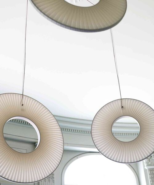 Moderne, kreisförmige Hängeleuchten mit transparenten Strukturen in einem hellen Innenraum.