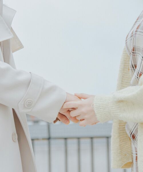 Zwei Personen halten sich sanft an den Händen, nur ihre Arme und Kleidung sind im Bild zu sehen.