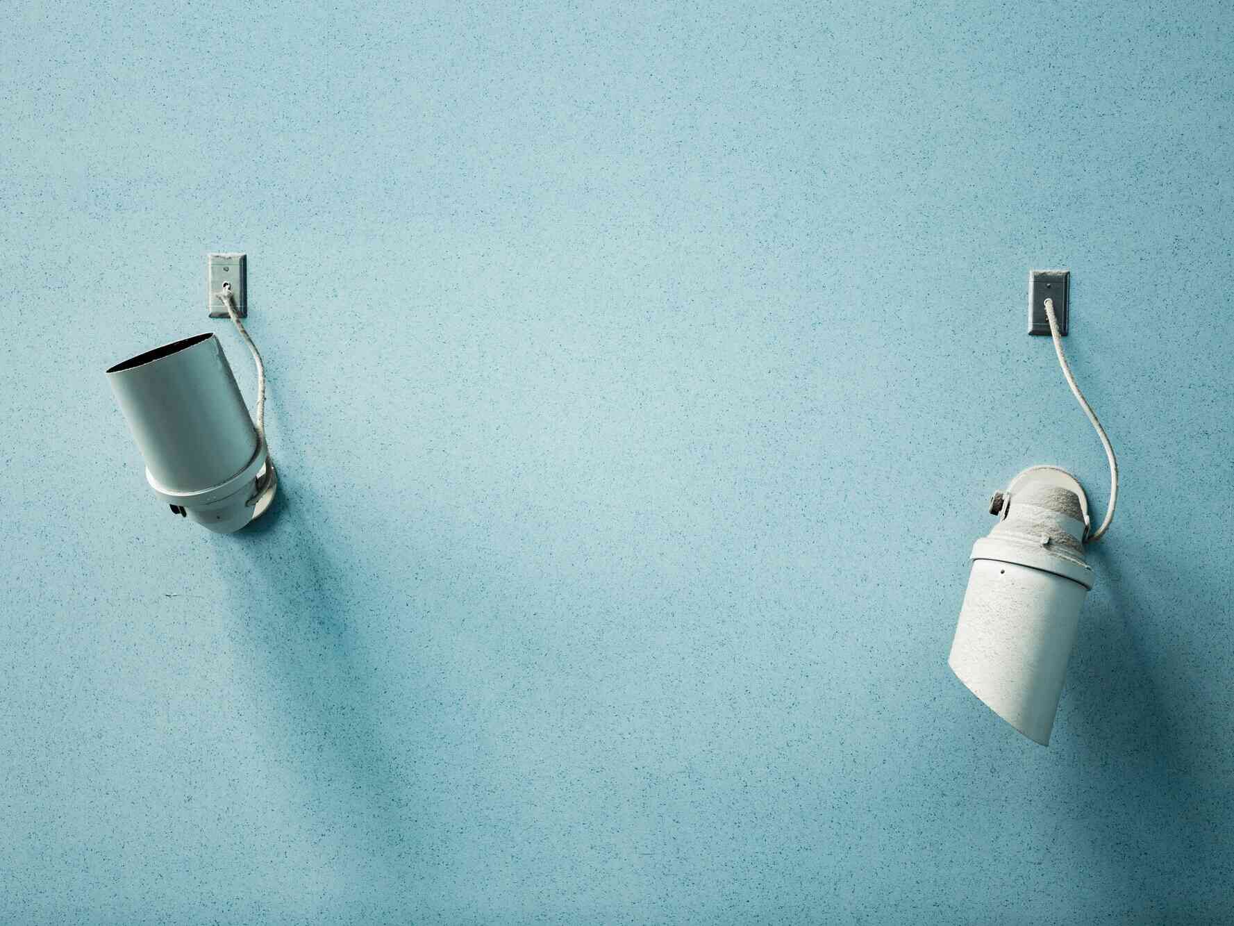 Helle Badezimmerwand in Blau mit teilweise sichtbaren Armaturen und Handtuchhalter.