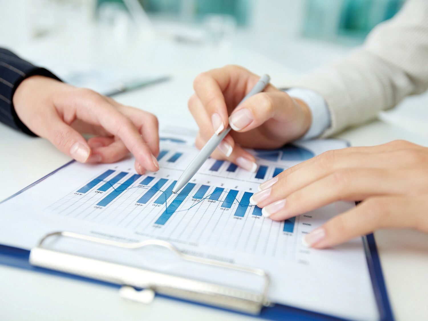 Zwei Personen analysieren gemeinsam ein Diagramm mit blauen Balken – Symbol für Datenanalyse und Zusammenarbeit.